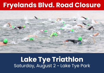 Image of swimmers for Lake Tye Triathlon with a road closure banner.