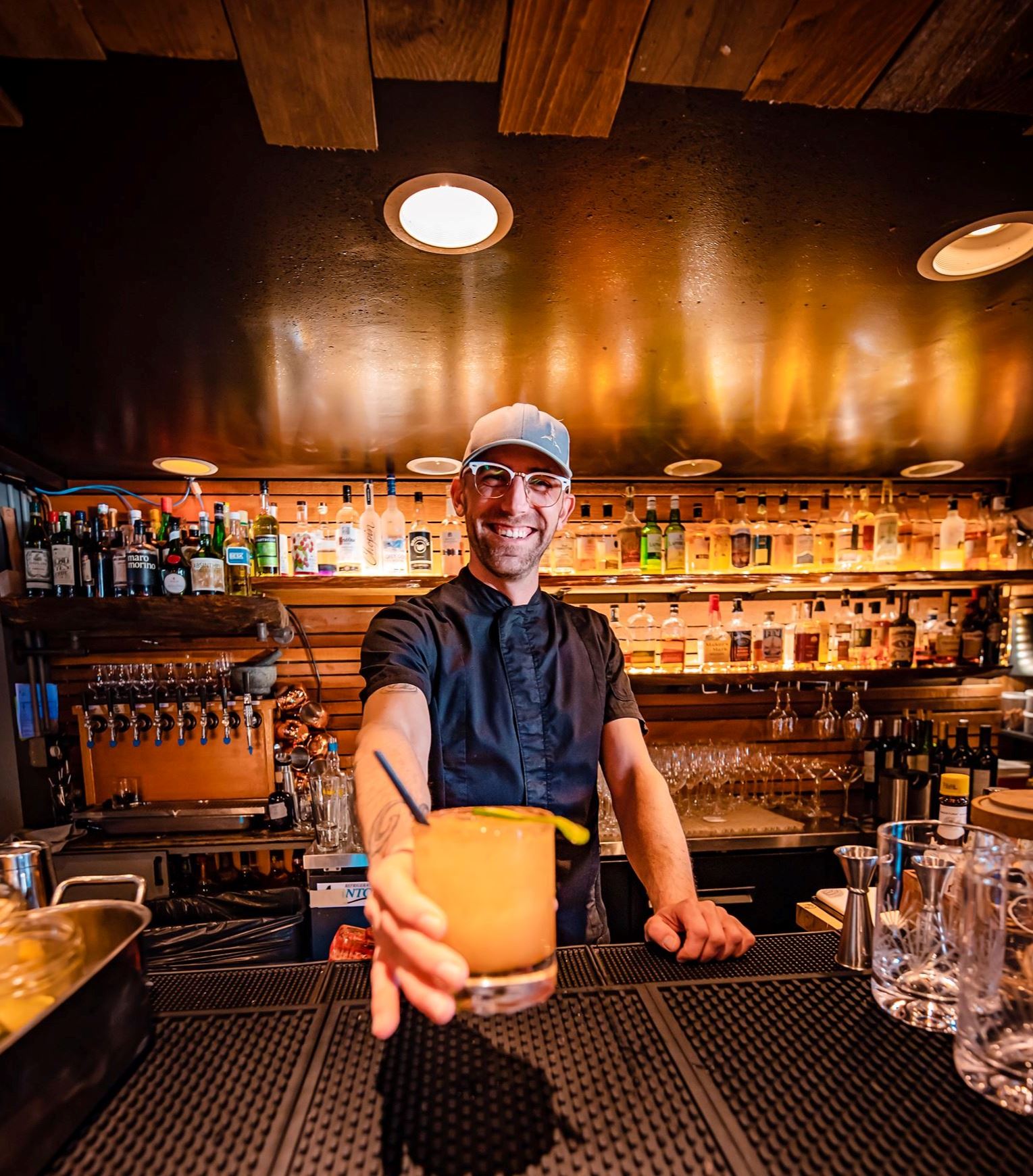 A Bartender at Lewis and Main serving a drink.